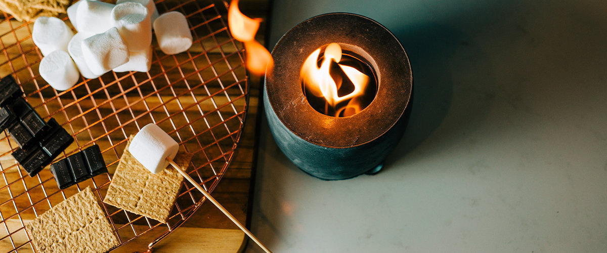 Smores kit next to a small gas fire pit.