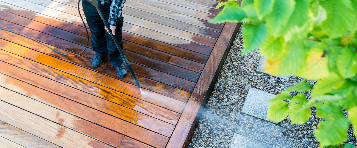 Man power washing a deck