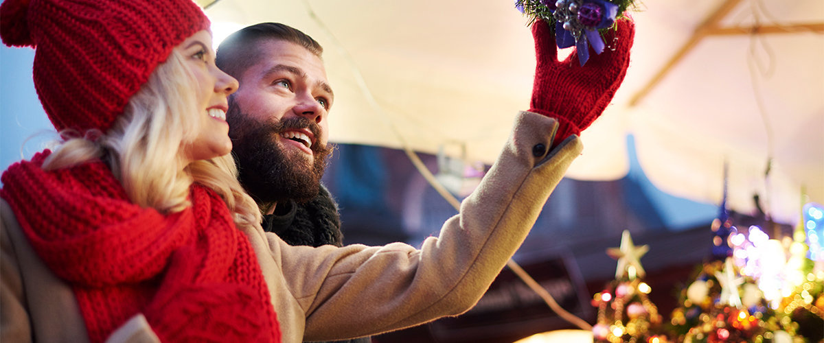 Couple putting up holiday decorations on patio
