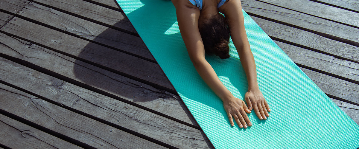 Woman doing yoga on backyard deck