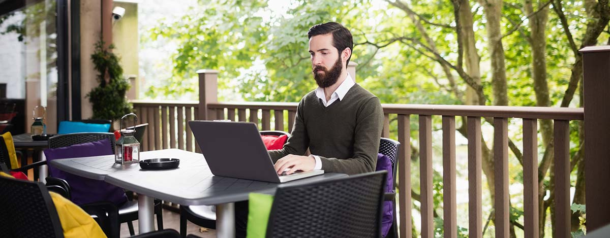 man using a laptop in a terrace